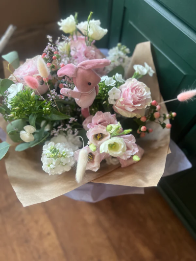 Baby Girl handtied - Soft white and pink seasonal flowers including contrasting foliages and a cute bunny. Hand tied and delivered in water. These are florist choice bouquets so flowers may be substituted if not available on that day.
